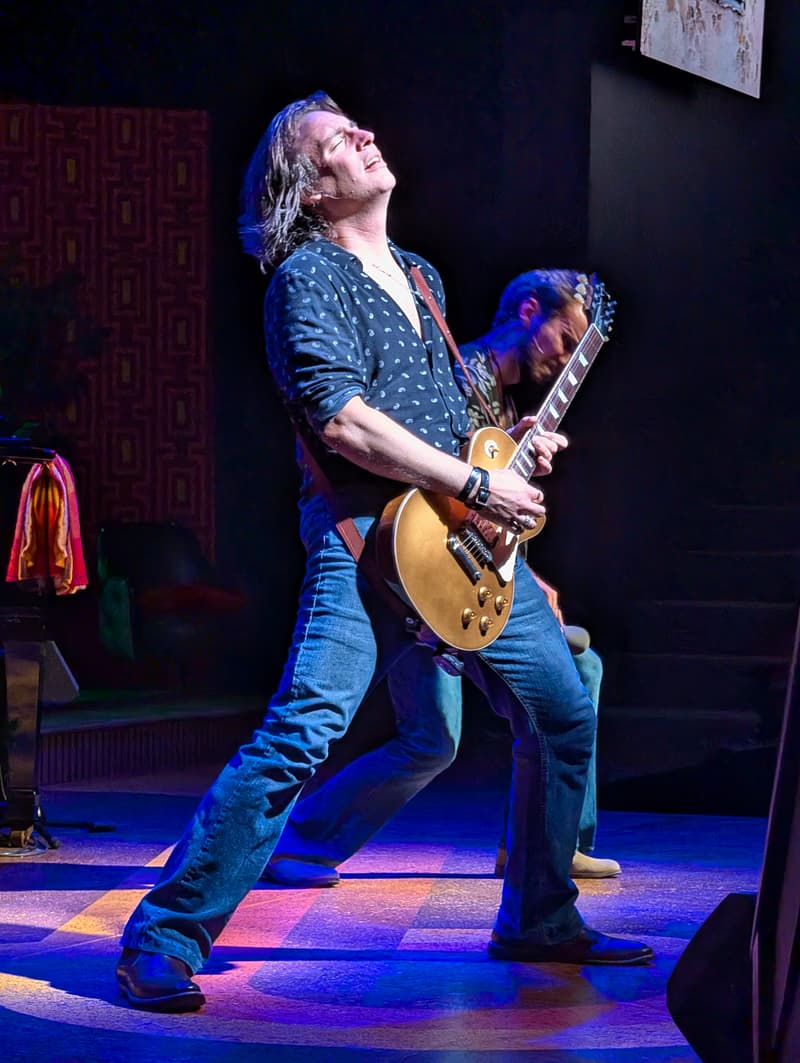 Garry Hall leaning back mid-solo on a Les Paul guitar under stage lights